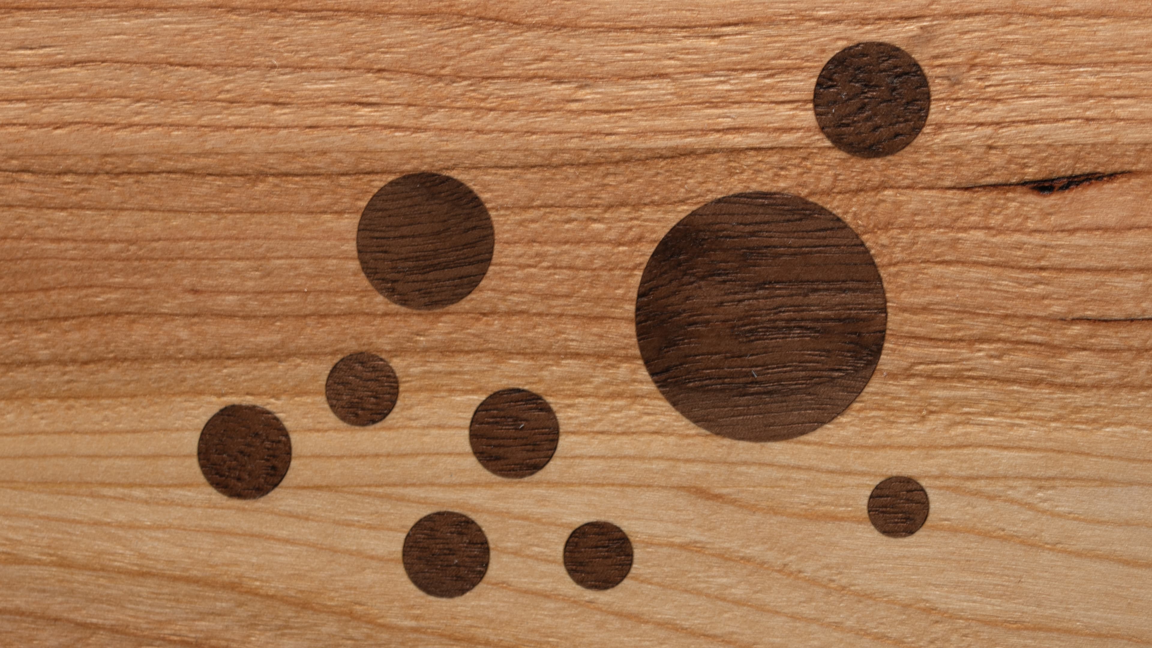 Walnut circles inlaid in cherry, up close — grain running against grain
